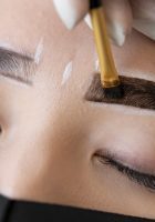 esteticista-haciendo-tratamiento-microblading-cejas-cliente